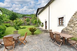 a patio with a table and chairs and a building at Puente del Narcea 4 in Cibuyo