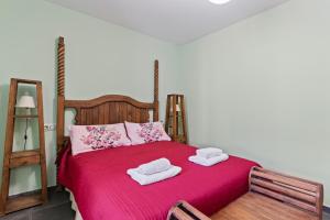 a bedroom with a red bed with two towels on it at Puente del Narcea 4 in Cibuyo
