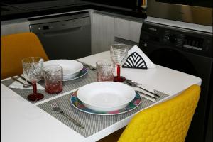 a white table with two plates and glasses on it at Apartamento ms in Campo Maior +9 photos