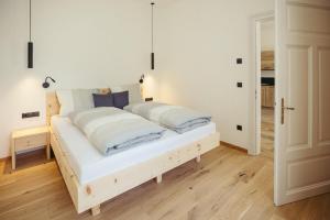 a bedroom with a white bed with blue pillows at Freienfeldhof Elstar in Lagundo