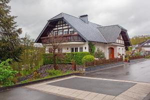 ein großes weißes Haus mit schwarzem Dach in der Unterkunft Ferienwohnung Hönneblick in Balve