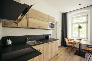 a kitchen with a sink and a table with chairs at Freienfeldhof Elstar in Lagundo