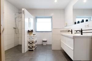 a white bathroom with a sink and a toilet at Speicherhäuschen Maren in Geeste +14 photos