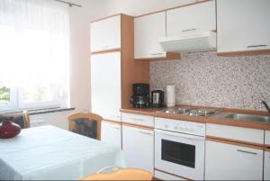 a kitchen with white cabinets and a counter top at Apartment für 2, nicht für Monteure in Niederau