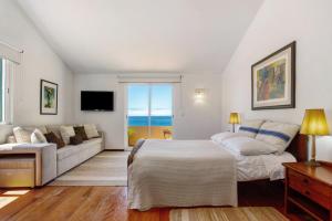 a bedroom with a bed and a couch at Bela Vigia in Jardim do Mar
