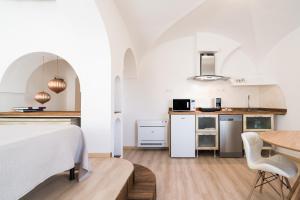 a kitchen and dining room with a bed and a table at Giojas125- Monolocale per 2 persone in Orosei +13 photos