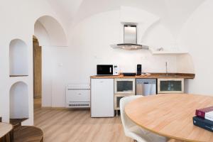 a kitchen with a wooden table and a wooden floor at Giojas125- Monolocale per 2 persone in Orosei