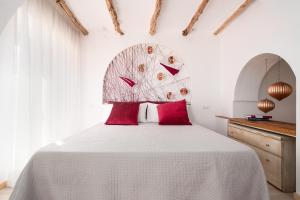 a bedroom with a large white bed with red pillows at Giojas125- Monolocale per 2 persone in Orosei
