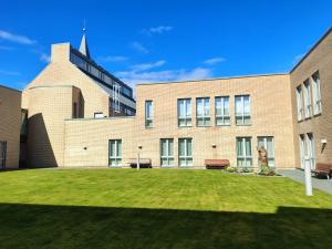 a brick building with a grassy yard in front of it at Birgittaklosteret i Trondheim in Trondheim