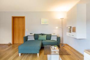 a living room with a blue couch and a table at Ferienwohnung Klein und Fein in Edertal