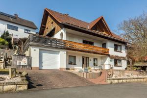 a large white house with a large garage at Ferienwohnung Klein und Fein in Edertal