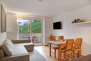 a living room with a couch and a table and chairs at Ferienwohnung Maier - Fontanella in Fontanella