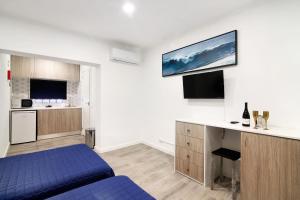 a bedroom with a blue bed and a kitchen at Apartamento nº4 - Beach in Moncarapacho