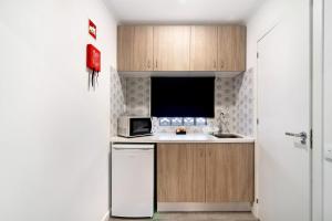 a small kitchen with a sink and a microwave at Apartamento nº4 - Beach in Moncarapacho