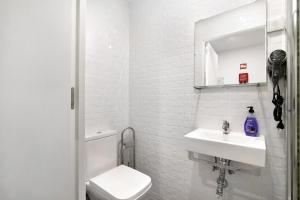 a white bathroom with a toilet and a sink at Apartamento nº4 - Beach in Moncarapacho +11 photos