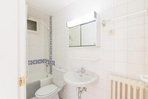 a white bathroom with a toilet and a sink at Masella in La Masella +29 photos