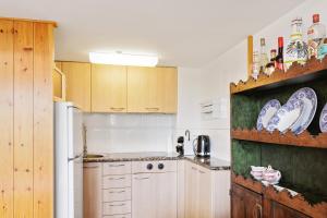 a kitchen with wooden cabinets and a white refrigerator at Masella in La Masella