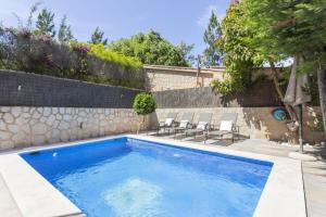 a swimming pool in a yard with chairs at Can Darder in Sóller