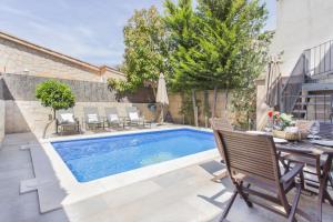a swimming pool with chairs and a table next to it at Can Darder in Sóller +7 photos