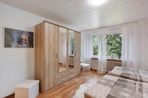 a bedroom with a bed and a large wooden cabinet at Sara´s Ferienwohnung in Plettenberg