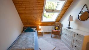 a attic bedroom with a bed and a window at Schwarzwaldferienwohnung Oberle in Todtnau