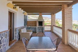 a patio with a table and chairs on a balcony at Villa El Peli in Nerja