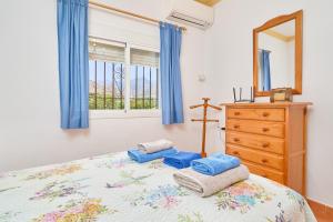 a bedroom with a bed with a dresser and a mirror at Villa El Peli in Nerja +23 photos