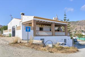 a house with a balcony on the side of it at Villa El Peli in Nerja