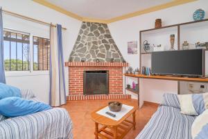 a living room with a fireplace and a tv at Villa El Peli in Nerja