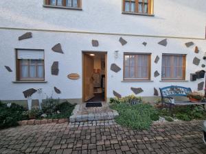 a white house with a wall with triangles on it at Ferienwohnung Kuckuck in Ohlsbach