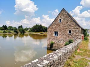a stone building next to a wall next to a river at L'idéal, wifi, proche mer et Vannes in Noyalo