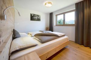 two beds in a room with a window at Teutenhofer Kastanie in Feldthurns