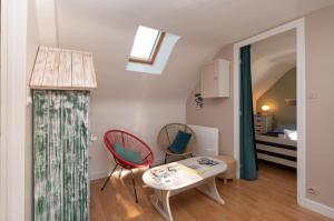 a room with two chairs and a table and a bed at L'idéal, wifi, proche mer et Vannes in Noyalo