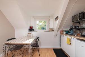 a small kitchen with a table and a window at L'idéal, wifi, proche mer et Vannes in Noyalo +14 photos