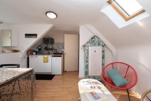 a kitchen and a living room with a table and chairs at L'idéal, wifi, proche mer et Vannes in Noyalo