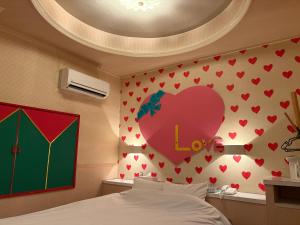 a bedroom with a heart on the wall at 福井ホテルシルビア in Fukui +1 photo