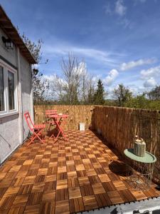 a patio with a table and chairs and a fence at La Romance in Acy-Romance