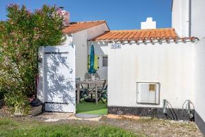 a white house with a door leading into a yard at Studio piscine partagée in Bretignolles-sur-Mer