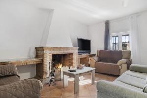 a living room with a fireplace and a tv at Casa Pilar in Ronda