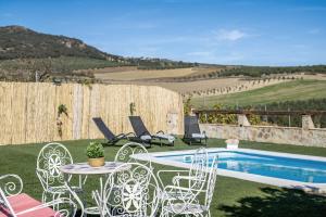 a patio with a table and chairs next to a pool at Casa Pilar in Ronda