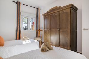 a bedroom with two beds and a large wooden cabinet at Casa Pilar in Ronda +22 photos