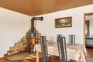 a fireplace in a dining room with a table and a stove at Möblierte Wohnung Ferienwohnung in Aicha vorm Wald