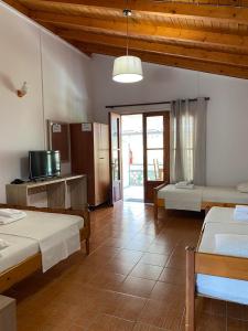 a large room with two beds and a television at 4 Seasons apartments in Himare