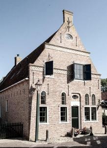a large brick building with a clock tower at Hylper Huis in Hindeloopen