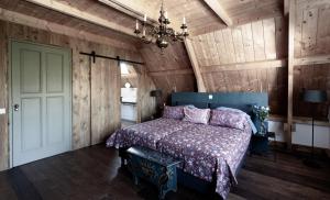 a bedroom with a bed in a room with wooden walls at Hylper Huis in Hindeloopen