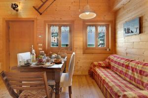 a dining room with a table and a couch at Chalet de La Poya in Valtournenche