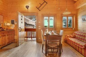 a dining room with a table and a couch at Chalet de La Poya in Valtournenche