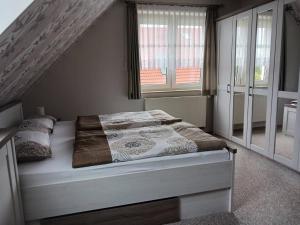 a bedroom with a bed in a room with windows at Apartment Kleine Auszeit in Wiendorf
