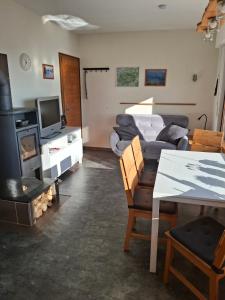 a living room with a couch and a tv at Ferienhaus Höhenflug in Attendorn