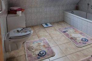 a bathroom with a toilet and a bath tub and rugs at Apartment Kleine Auszeit in Wiendorf